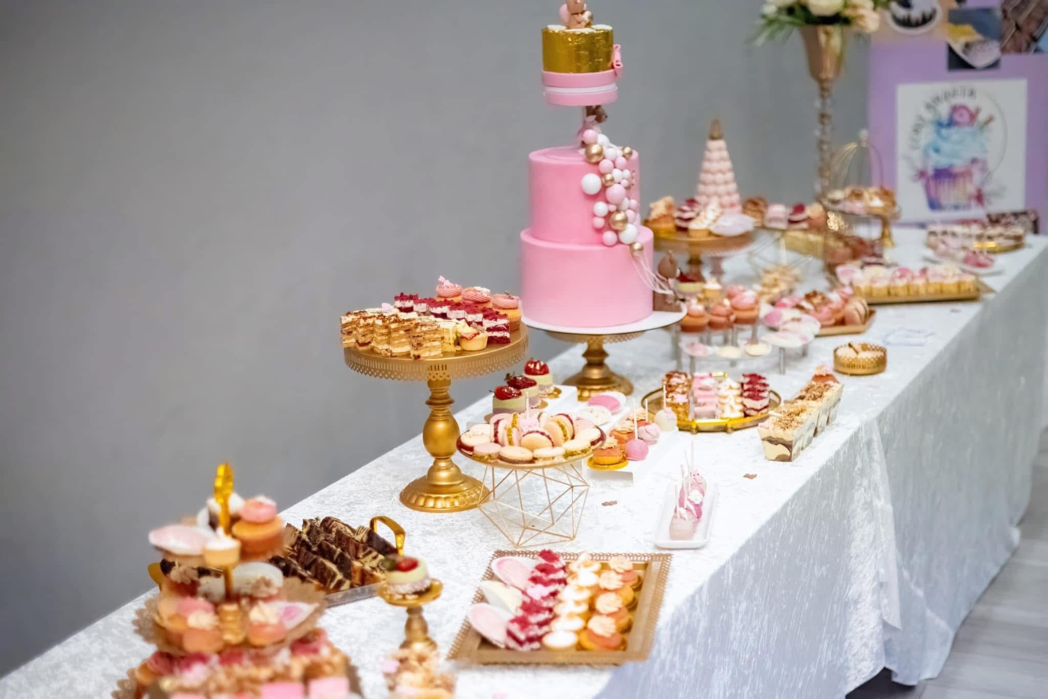 Candy bar elegant roz și auriu cu tort etajat și deserturi artizanale pentru eveniment
